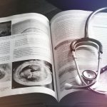 Stethoscope resting on an open medical book